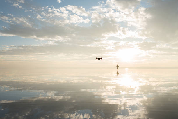 istock Photographer  having fun with Drone on salt lake at sunset 890117954