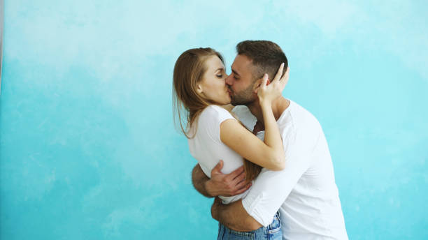 istock Young happy couple kissing on blue background 890118338
