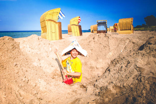 chłopiec kopie w piasku na plaży nad morzem - seat row obrazy zdjęcia i obrazy z banku zdjęć
