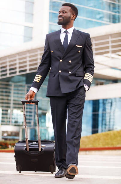 Black person pilot walking at the airport Black person pilot walking at the airport piloting stock pictures, royalty-free photos & images