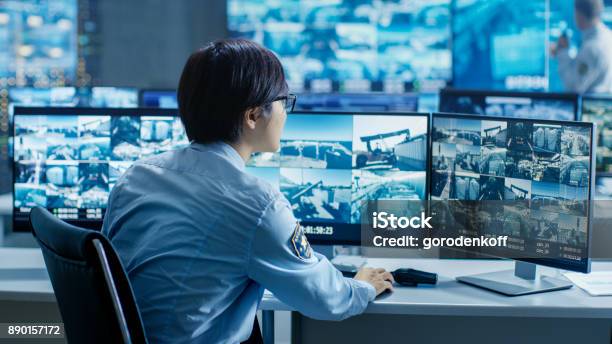 In The Security Control Room Officer Monitors Multiple Screens For Suspicious Activities Hes Surrounded By Monitors And Guards Facility Of National Importance Stock Photo - Download Image Now