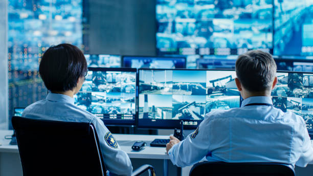 In the Security Control Room Two Officers Monitoring Multiple Screens for Suspicious Activities, They Report any Unauthorised Activities. They Guard Object of National Importance. In the Security Control Room Two Officers Monitoring Multiple Screens for Suspicious Activities, They Report any Unauthorised Activities. They Guard Object of National Importance. terminal tower stock pictures, royalty-free photos & images