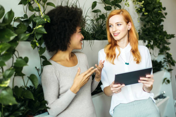 istock Two young business women talking in the office 890161514
