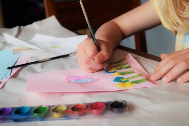 Child making Mother’s Day card. Traditional play concept.