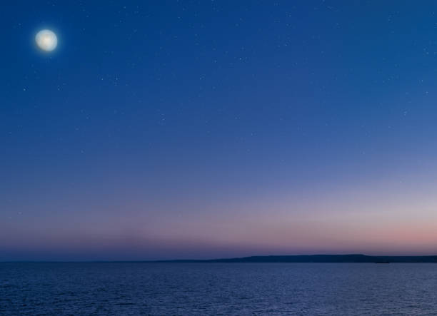 istock Moon and stars over the calm sea. 890176640
