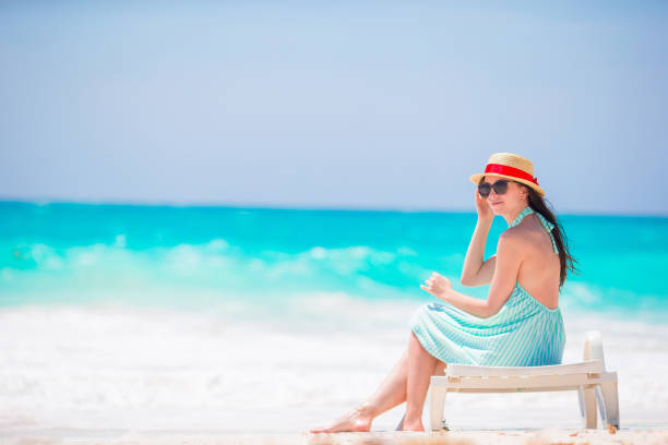 Relaxing and enjoying on summer vacation, woman lying in sunbed on beach