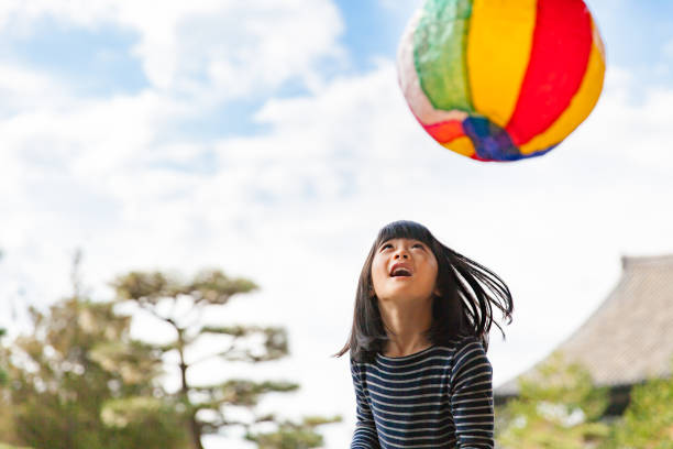 istock Girls playing with paper balloon 890190112