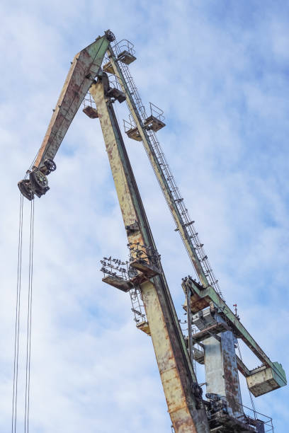 istock Crane on port with blue sky in background 890192334