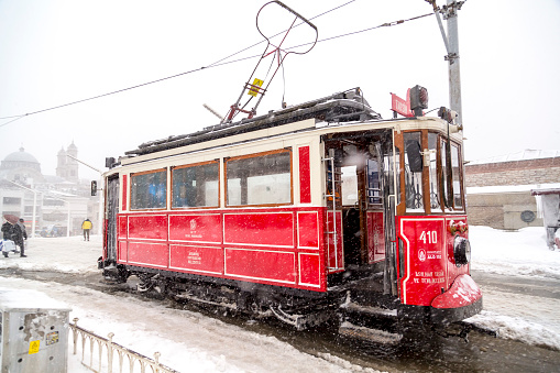 Istanbul, Turkey - January 7, 2017: Istanbul under heavy snow on January 7. People passing through the Istiklal Avenue by the nostalgic red tram from one end to another of the avenue.