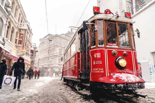 Istanbul, Turkey - January 7, 2017: Istanbul under heavy snow on January 7. People passing through the Istiklal Avenue by the nostalgic red tram from one end to another of the avenue.