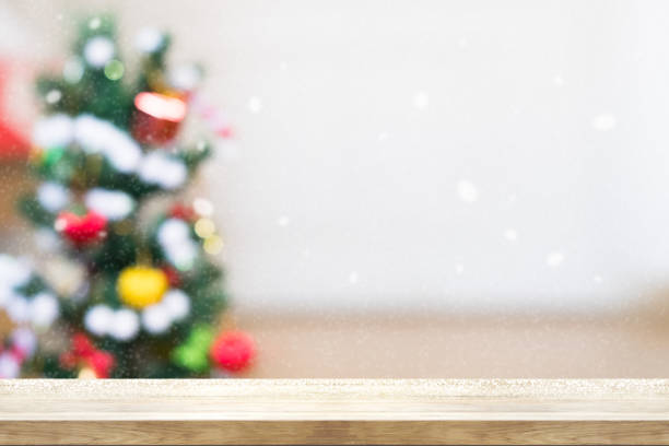 istock Wooden table top with blur Christmas tree background in snowfall. Can be used product display. 890199180
