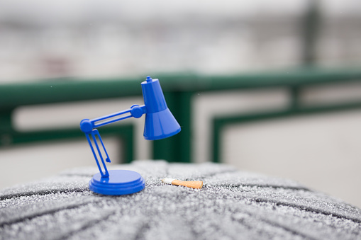 Small blue reading lamp in centr of city. Trash at the tram depot. Cracov in Poland.