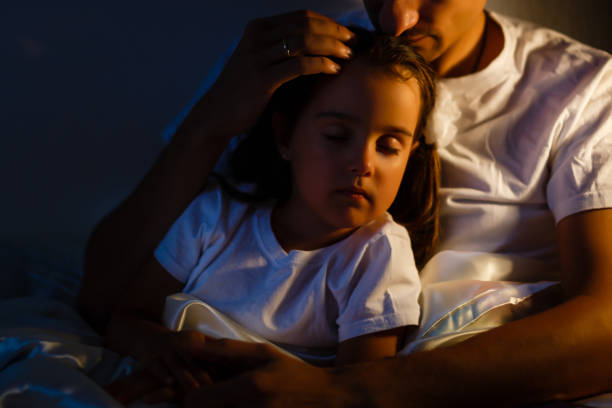 Little daughter fell asleep at the father while reading the book