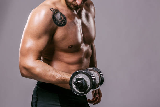 Dumbell workout Athlete work on his biceps with kettlebell wrestlers uniform stock pictures, royalty-free photos & images