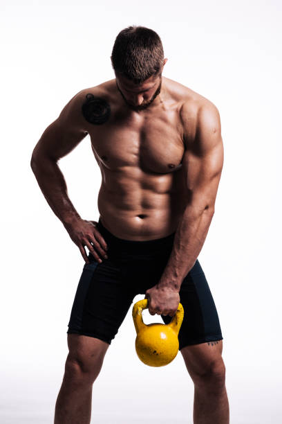 Lean body of a young athlete Pure strength of a young athlete working with dumbell wrestlers uniform stock pictures, royalty-free photos & images