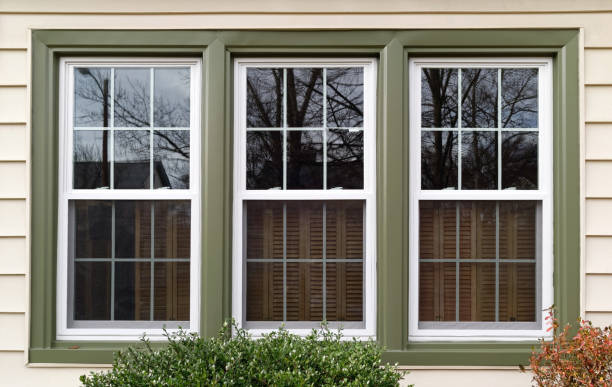 Replacement Windows Three new replacement windows with green trim on front of house. Horizontal. radial symmetry stock pictures, royalty-free photos & images