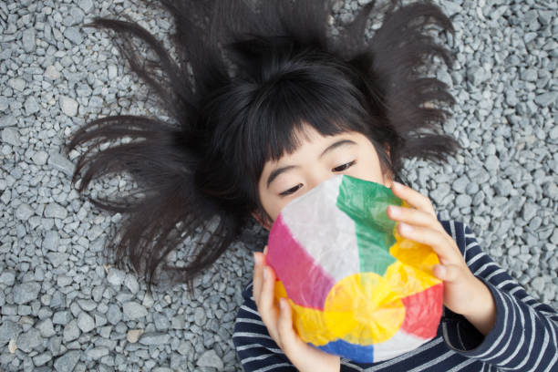 istock Girls playing with paper balloon 890221504