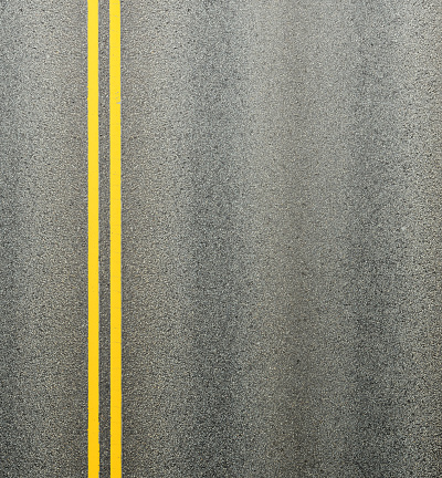 Carretera asfaltada y doble líneas amarillas que dividen los carriles. photo