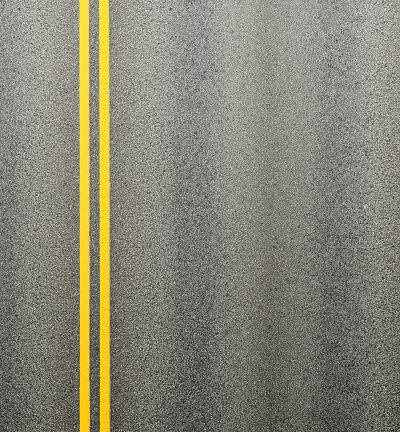 Asphalt road and double yellow lines dividing the lanes.