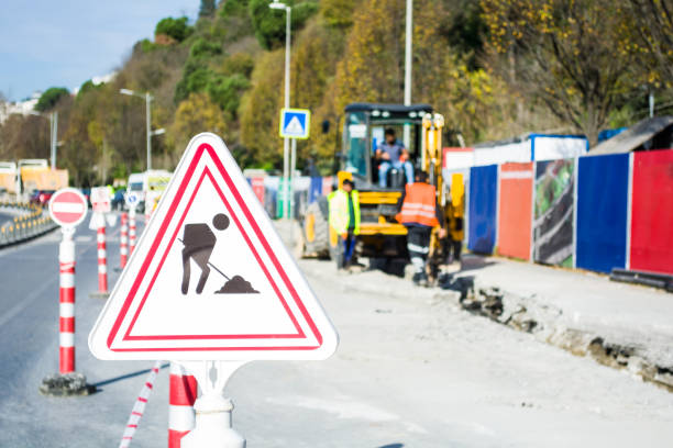 istock of two workers and an excavator on a road construction 890226406