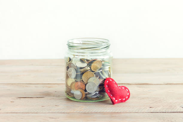 Coins in glass jar with red heart