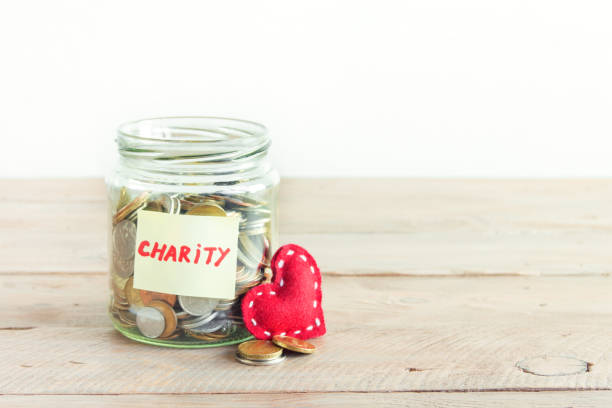 istock Coins in glass jar with red heart 890227406
