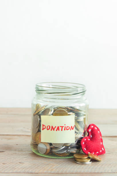 istock Coins in glass jar with red heart 890227442