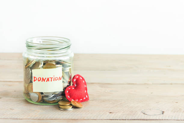 istock Coins in glass jar with red heart 890227444