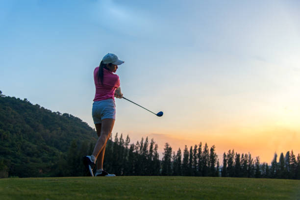 istock Asian woman golf player doing golf swing tee off on the green sunset evening time, she presumably does exercise.  Healthy and Lifestyle Concept. 890230838