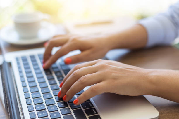 istock Close-up of female hands typing on laptop keyboard 890238580