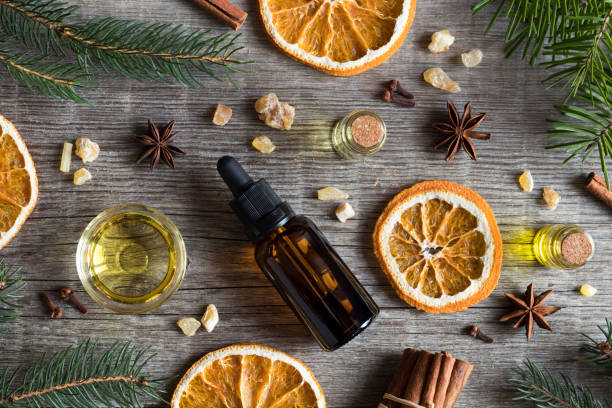 selección de aceites esenciales y especias de navidad ingredientes sobre un fondo de madera - christmas anise star anise clove fotografías e imágenes de stock