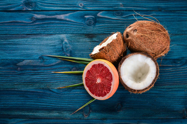 Coconut and grapefruit. Fresh fruits. On a wooden background. Top view. Free space for text.