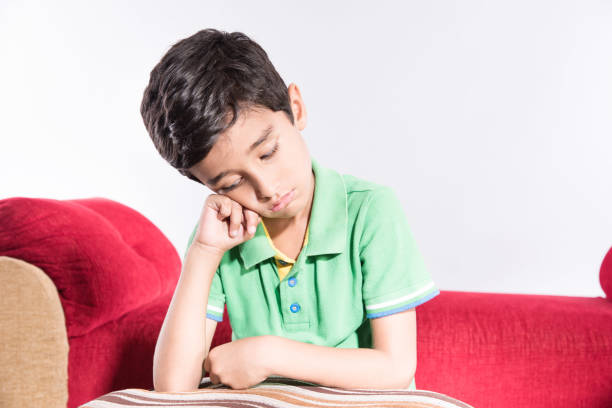 Arabic child sitting at home sad with white background