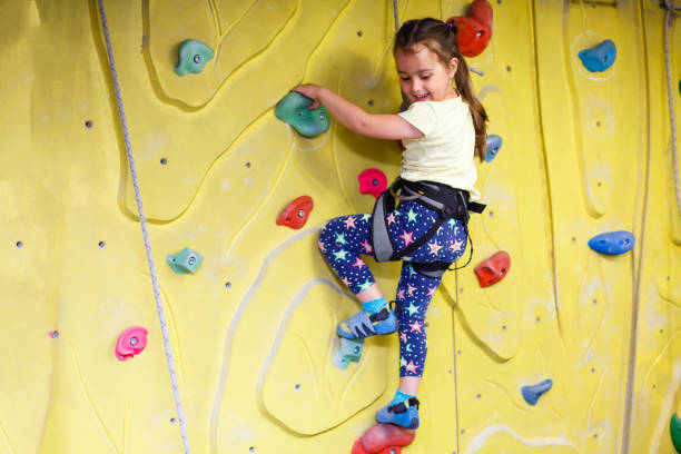istock little girl climbing a rock wall indoor 890257776