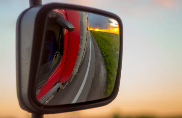 reflexionen auf den sonnenuntergang in den rückspiegel des lkw - car side view truck truck driver stock-fotos und bilder