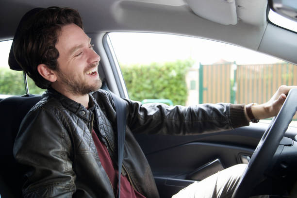 istock Handsome happy man driving car smiling 890264228