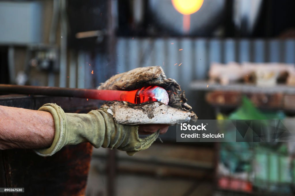Traditional glassblowing worker cutting liquid glass Fire - Natural Phenomenon, Flame, Murano, Malta, Glass - Material Art Stock Photo