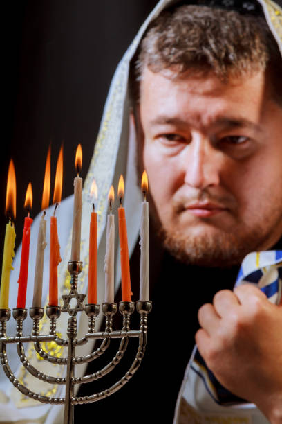 ハヌカ、ユダヤ人の祭典。本枝の燭台の燃焼蝋燭 - menorah hanukkah candle human hand ストックフォトと画像