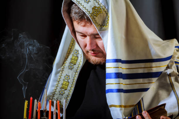 istock male hand lighting candles in menorah on table Hanukkah 890270444