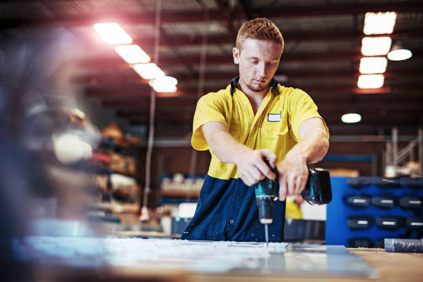 istock Ginger Australian guy working with drill in factory 890273236