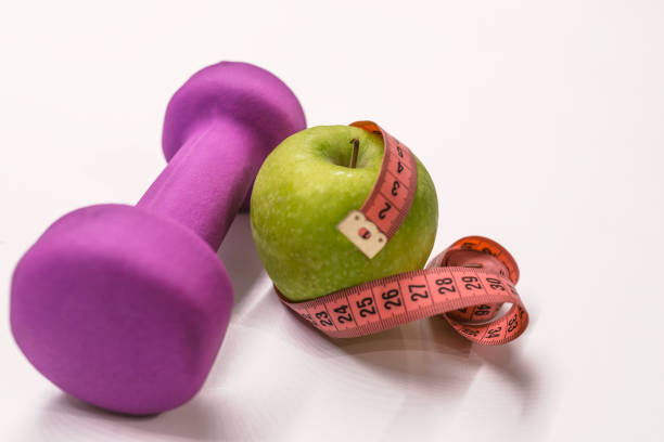 istock An apple, a measuring tape and dunbbell 890285176