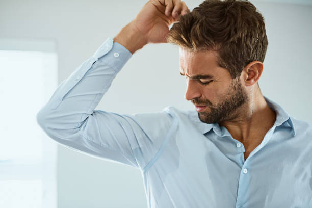 That doesn't smell good Shot of a handsome young man smelling his armpits at home sweat stock pictures, royalty-free photos & images