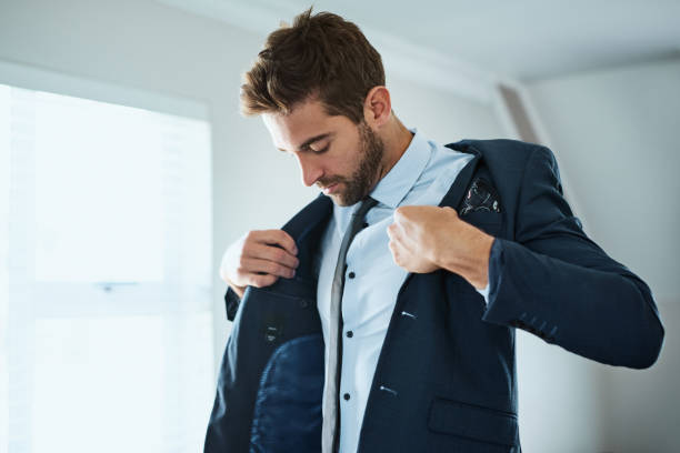 This completes the look Shot of a handsome young man dressing himself at home blazer jacket stock pictures, royalty-free photos & images