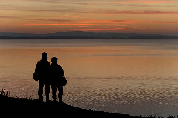 Sunset over lake in sunset in SwedenSiluette people on the jetty pier in evening