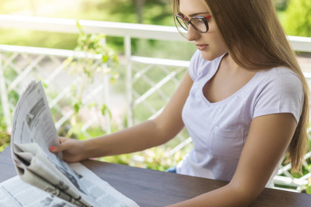 istock Woman reading newspaper on balcony 890305500