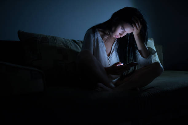 istock Tired woman using blue smartphone screen at night dark room 890305616
