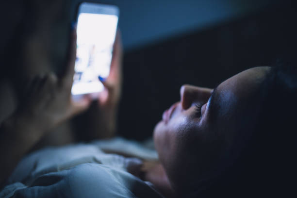 istock Woman using blue screen of smartphone at night before sleep 890305846