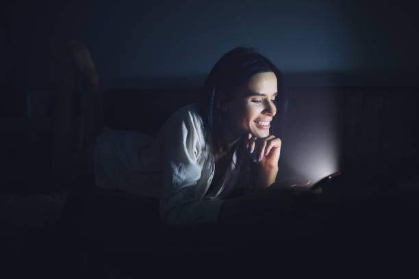 istock Woman using blue screen of smartphone at night before sleep 890305884
