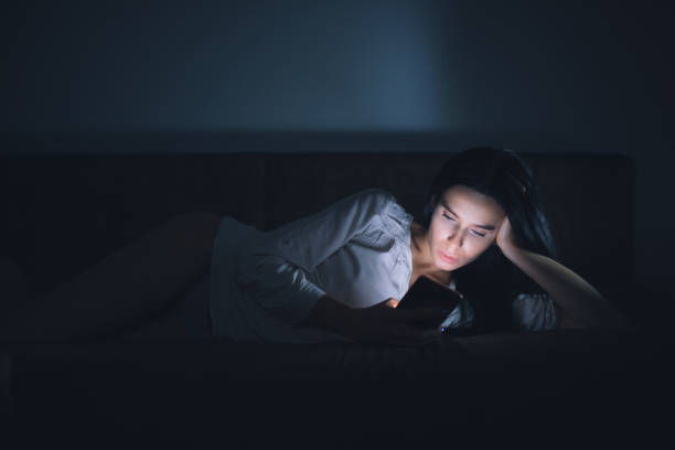 istock Woman using blue screen of smartphone at night before sleep 890305954