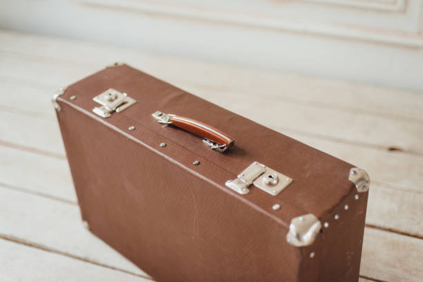 istock Close up of old brown suitcase on the white boardwalk floor 890319582